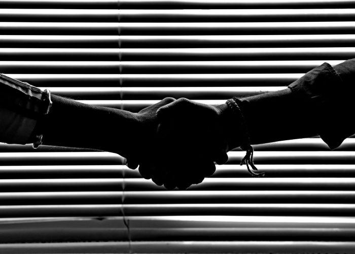 pexels-photo-814544-814544 Silhouette of two people shaking hands symbolizing partnership and trust.